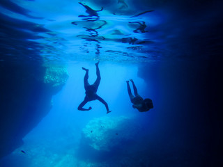 Fototapeta premium Two persons dive into the blue water