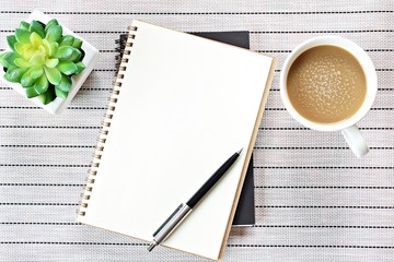 Still life, business, office supplies or education concept : Top view or flat lay image of open notebook with blank pages and coffee cup on table background, ready for adding or mock up