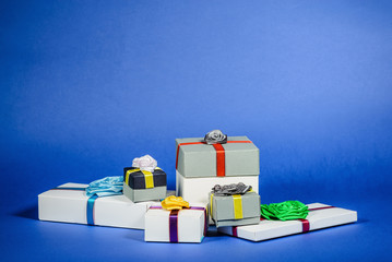 Set of multicolored gift boxes with bows on a blue background