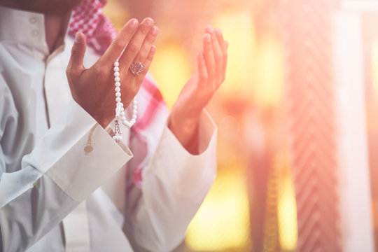 Hands holding tasbih of a religious man praying inside the mosque