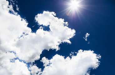 Céu azul com sol e nuvens.