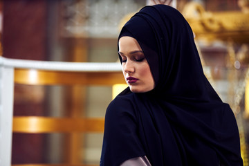 Young pretty muslim woman in hijab praying inside the mosque