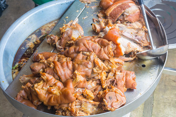 Cooked Stewed pork leg warmed on Aluminium Tray Over Gas Stove ready to Chop and Serve with Rice.