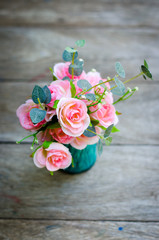 pink rose Flowers in a vase on wood table, vintage style for background.