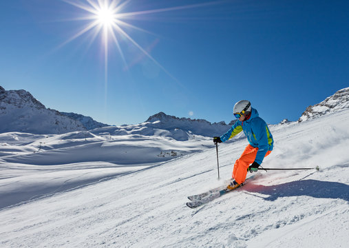 Skier skiing downhill in high mountains