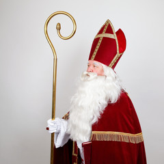 Saint Nicholas looks at his staff on white