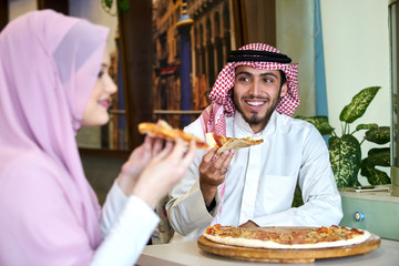 Young religious couple having pizza