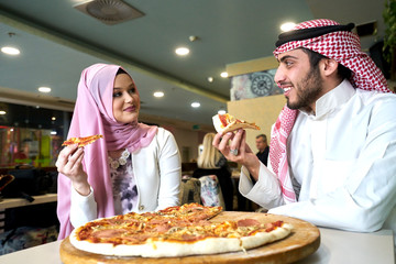 Young religious couple having pizza