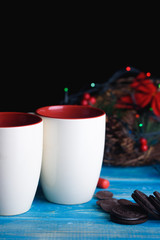 Two New Year's cups for tea with chocolate cookies on the table