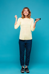 Full length image of Happy woman in sweater rejoice