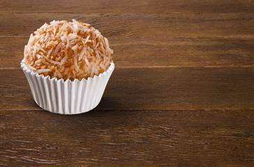 Traditional Brazilian sweet on wood background. Cocada.