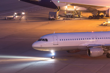 passenger aiplane moving on an airport at night