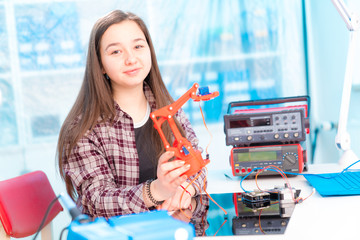 Schoolgirl in laboratory robots debug microcontroller