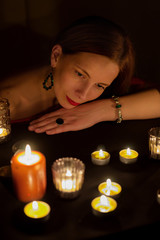 green-eyed fortune teller looks at a candle flame