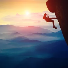 Gordijnen Silhouette of climber girl on a cliff © Bashkatov