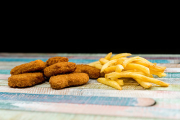 Chicken nuggets with sauce and golden French fries potatoes