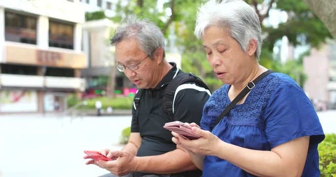 Asian senior couple use of cellphone together