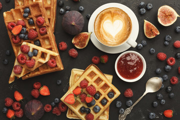 Belgium waffles with berries, tasty breakfast on black background