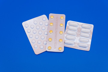 Medications, pills and a thermometer on a bright background