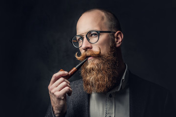 A man smoking pipe over grey background.