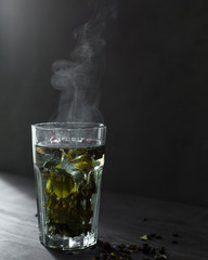 Hot tea with lemon, honey and berries in a glass is very good in the cold season with a rug and book. The steam from the tea is very beautiful)