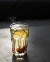 Hot tea with lemon, honey and berries in a glass is very good in the cold season with a rug and book. The steam from the tea is very beautiful)