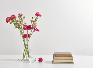 vase of red flowers with books white wall decoartion
