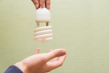 Energy saving light bulb in the hands of a man