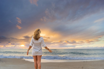 Fototapeta na wymiar Woman on the beach at sunset in Asia