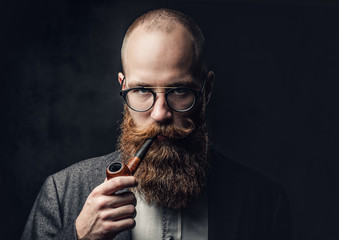 A man smoking pipe over grey background.