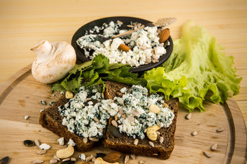 closeup cottage cheese with spirulina powder on two pieces of brown bread