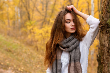 Young girl with long brown hair in autumn park