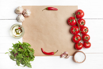 Fresh salad ingredients on brown paper. Top view, flat lay, copy space, white wooden background.