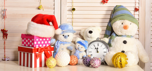 Toys placed on bureau on wooden wall background.