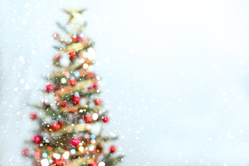 Blurred of Christmas tree and light bokeh with snowfall on winter background