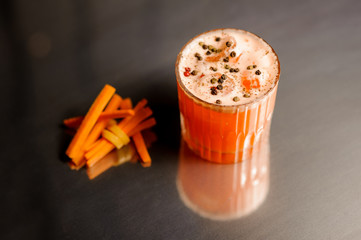 Glass of fresh and healthy carrot cocktail decorated with pepper