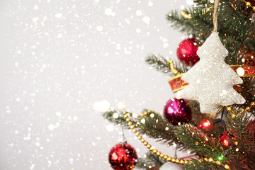 Fototapeta na wymiar Close-up of Christmas tree with ornament, decoration and light bokeh with snowfall on winter background
