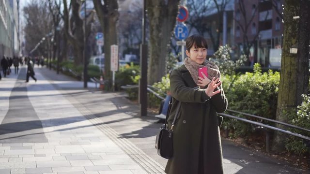 若い女性　待ち合わせイメージ　手をふる　原宿表参道　スロー