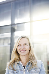 modern young business woman in casual look in front of glass building