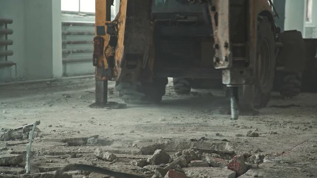 Dismantling the concrete floor: demolition machine destroys the concrete coating, close-up. Repair work with the special equipment: machine for dismantling. Drilling. No people