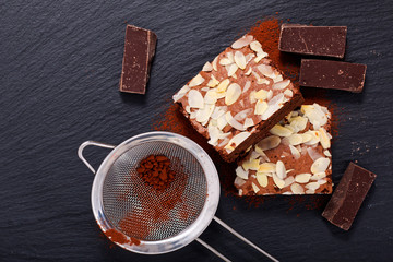 Homemade organic brownies on black slate stone with copy space