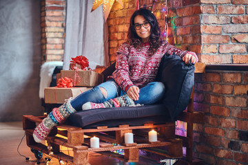 Brunette female in a room with Christmas decoration.