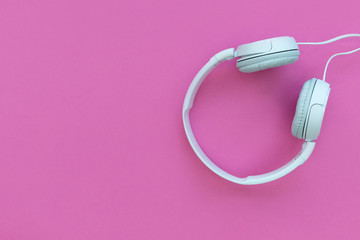 White music headphones on bright pink background