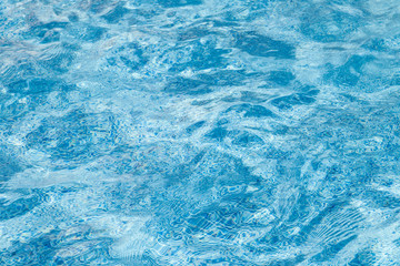 The water surface background of a swimming pool with waves and ripples. Blue wallpapper