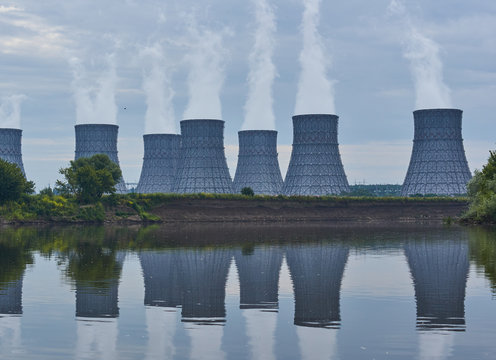 Cooling towers of a nuclear power plant on the river bank.