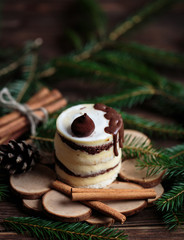Christmas tasty cake on dark wooden background with spruce decoration.