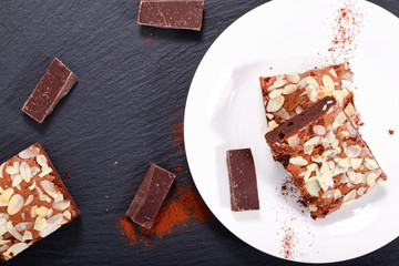 Homemade organic brownies on black slate stone with copy space