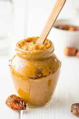 Date Caramel Sauce in Jar with Wooden Spoon inside It, Vertical View