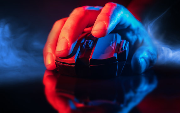 Close up of Hand over wireless Game Mouse on dark background and smoke ; The finger ready to click