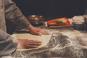 Hands kneading dough for pizza making